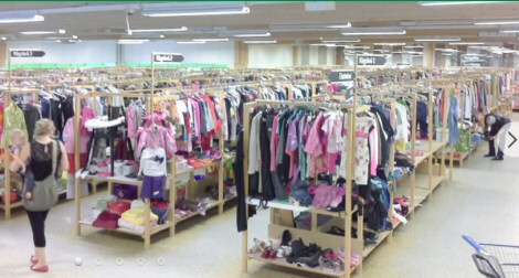 Avara myyntitila, jossa valtavasti myyntipöytiä, joissa erilaisia vaatteita, jalkineita ja muita tavaroita.