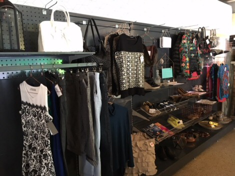 Valokuva vaaterekistä ja hyllyköstä täynnä jalkienita, naisten vaatteita ja käsilaukkuja.