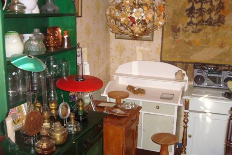 Valokuva tunnelmallisesta nurkkauksesta Wanhan Mökin Kirppiksellä. Täynnä erilaisia esineitä ja kalusteita.