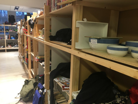 Puuhyllykkö, jossa useita tilavia lokerikkoja täynnä erilaista kirppistavaraa.