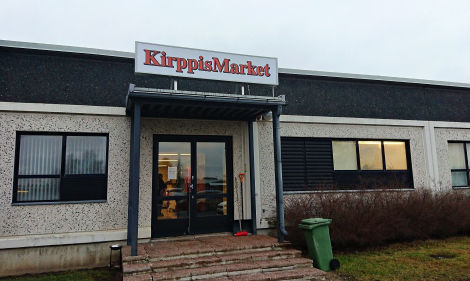 Kuvassa Seinäjoella sijaitseva Kirppismarket. Kuvasta kiitos Harrille. Värivalokuva KirppisMarketin julkisivusta kuvattuna syksyisenä, lumettomana päivänä. Marketin ovensuussa on portaikko ja oven yllä kirppiksen nimikyltti.