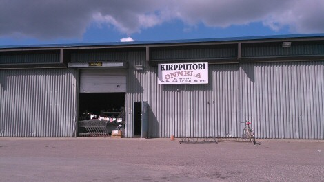 Kirpputori Onnelan julkisivu sinistä, osin pilvistä taivasta vasten.