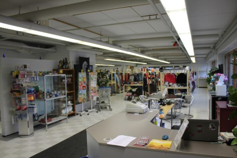 Etualalla kassa-alue, taaempana myyntihyllyjä täynnä erilaisia tavaroita.