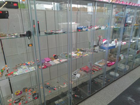 Lasivitriinit täynnä kaikenlaisia pieniä koristeita ja koruja.