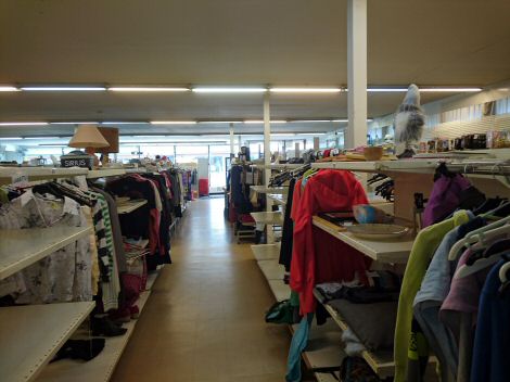 Vaatteita, astioita ja muita tavaroita myyntipaikat pulloillaan vasemmalla ja oikealla puolen.
