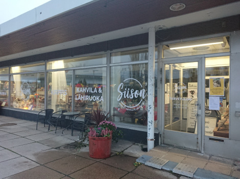 Valokuva Siison-kirppiksen julkisivusta, jossa suuret lasi-ikkunat ja ovensuu oikealla.