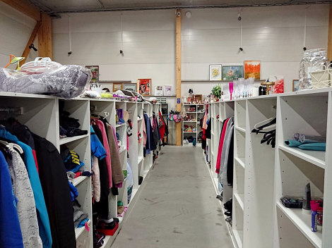 Valkoisia myyntipöytiä vasemmalla ja oikealla, sekä kaukana käytävän päässä.