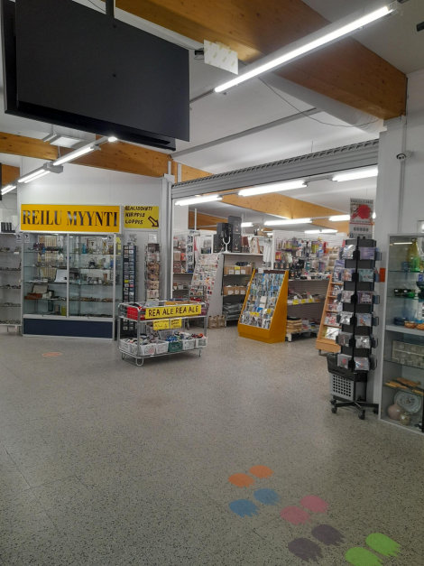 Kuvassa Reilu Myynti -liikkeen sisääntulo, jossa oviaukon ympärillä kaikenlaista pientavaraa myynnissä.
