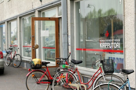 Heli-kirpparin julkisivu Lieksassa. Ovensuun ympärillä polkupyöriä.