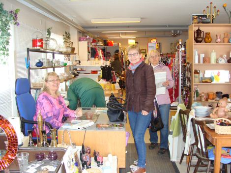 Valokuva Löytölähteen tiloista täynnä kaikenlaisia pieniä ja suuria esineitä, sekä muutamia asiakkaita.