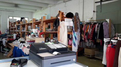 Puisia myyntihyllyjä ja niiden takana vaaterekkejä täynnä kaikenlaista.